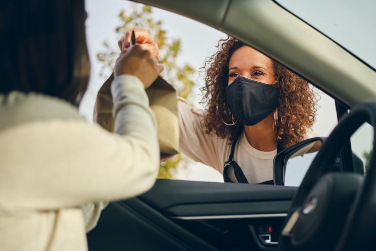 Man in car excepting product from vendor